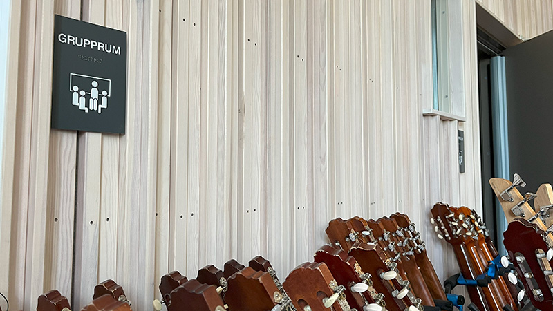 Träpaneler på vägg och gitarrer.