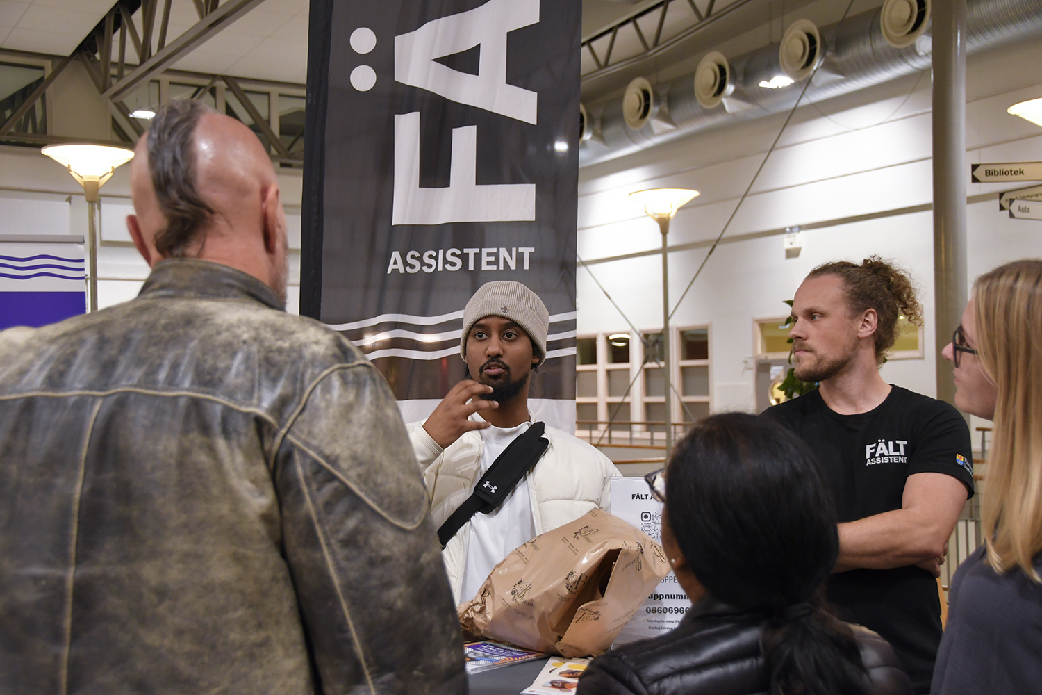 Kvällens föreläsare samtalar med besökare vid Fältassistenternas monter.