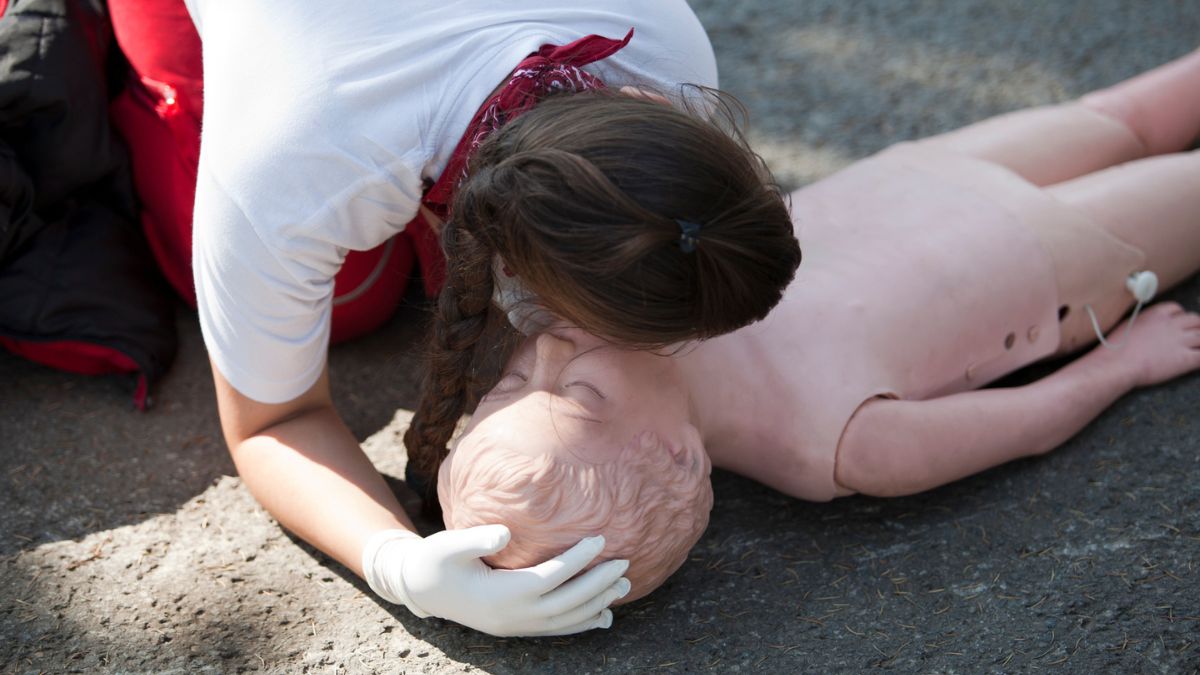 Person som övar hjärtlungräddning på en docka