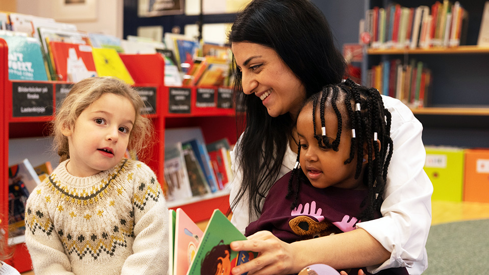 Kvinna läser för två barn.