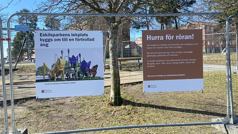 Informationskyltar på byggstängsel runt Eskilsparkens lekplats