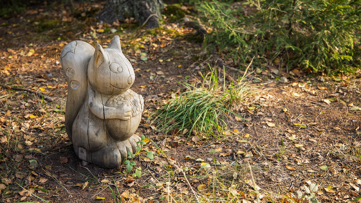 Träfigur i form av en ekorre i skogen