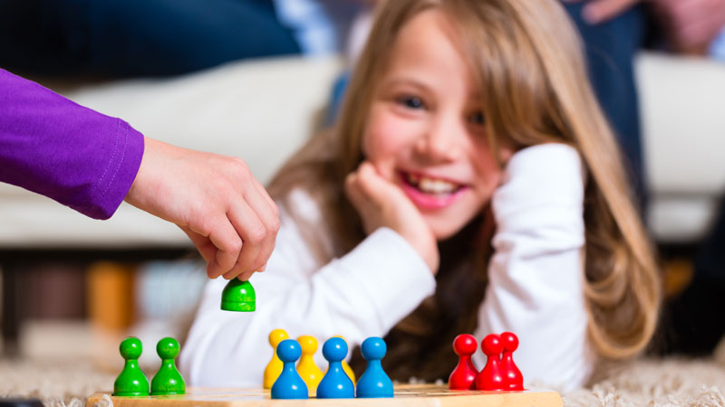 En glad flicka ligger på golvet